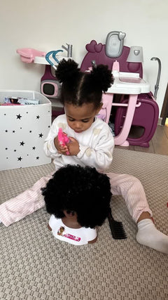 Enfant qui coiffe la tête à coiffer noire aux cheveux afro Little Happy